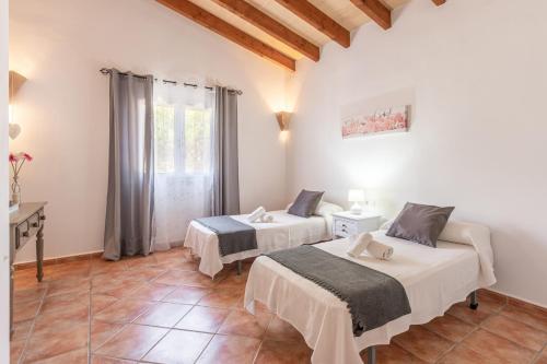 two beds in a room with a window at Villa Paqui in Portopetro