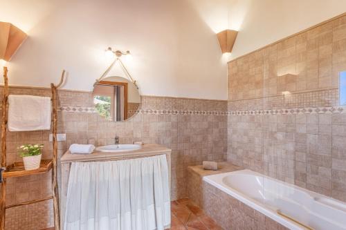 a bathroom with a tub and a sink at Villa Paqui in Portopetro