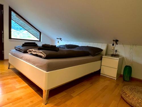a large bed in a room with a window at Black Forest Brandenkopfblick in Zell am Harmersbach