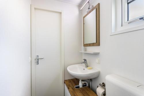a white bathroom with a sink and a mirror at Chalet 91 in Brilon