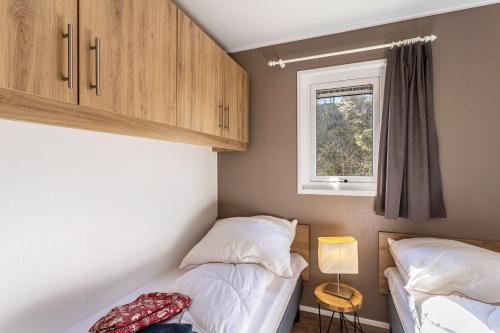 a small bedroom with two beds and a window at Chalet 91 in Brilon