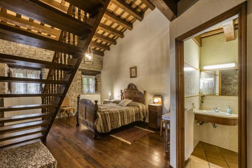 ein Schlafzimmer mit Bett und ein Badezimmer mit Waschbecken in der Unterkunft Can Tapis in Santa María de Camós