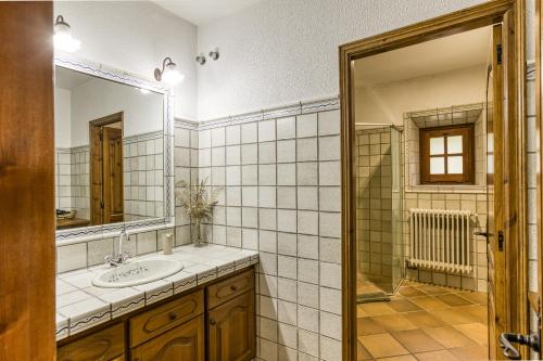 ein Badezimmer mit Waschbecken und Spiegel in der Unterkunft Can Tapis in Santa María de Camós