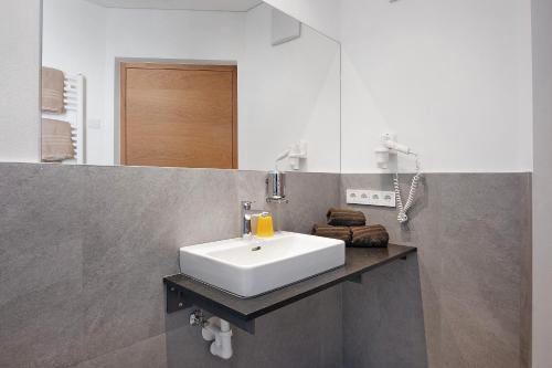 a bathroom with a white sink and a mirror at Hof Am Egg in Malles Venosta