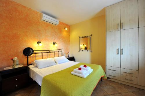 a bedroom with a bed with two towels on it at Villa Casa Bianca Orange Apartment in Gaios