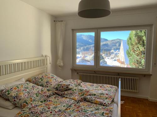 a bedroom with a bed and a large window at Lichtblick unter der Buche in Titisee-Neustadt