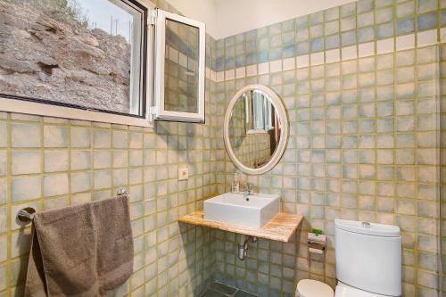 a bathroom with a sink and a mirror and a toilet at Finca Vidalenta El Salobre in Salobre