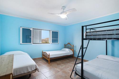 a bedroom with two bunk beds and blue walls at Finca Vidalenta El Salobre in Salobre