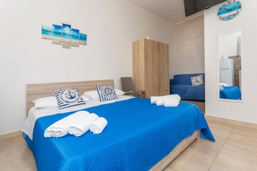 a bedroom with a blue bed with towels on it at Da Pina E Lu in Giardini Naxos