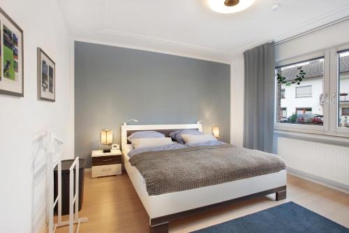 a white bedroom with a bed and a window at Stadt Land Fluss Plus in Arnsberg