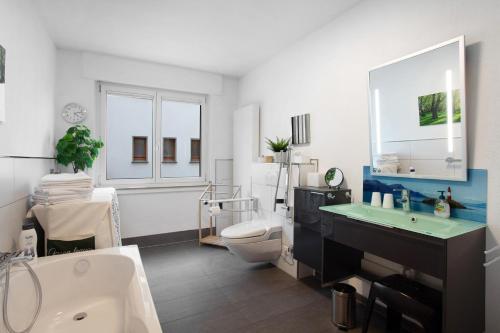 a bathroom with a tub and a toilet and a sink at Stadt Land Fluss Plus in Arnsberg