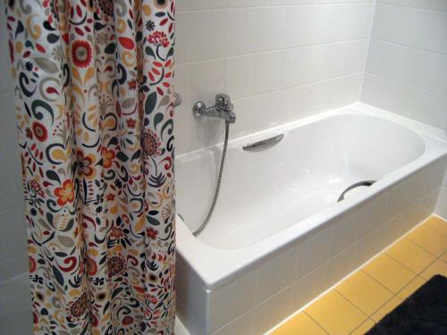 a bath tub in a bathroom with a shower curtain at Ferienwohnung Schwanbergblick in Mainbernheim