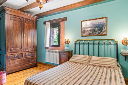 a bedroom with a bed and a wooden cabinet at Lorences A in Caunedo