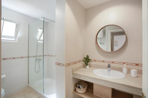 a bathroom with a sink and a shower and a mirror at Mangueros Suite 36 Puerto de Mogán in Puerto de Mogán