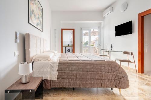 a white bedroom with a bed and a table at I 4 Venti in Melendugno