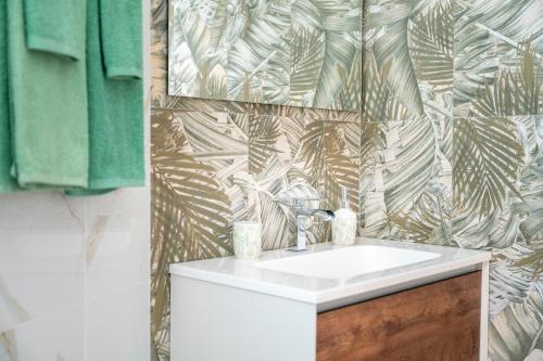 a bathroom with a sink and a tropical wallpaper at I 4 Venti in Melendugno