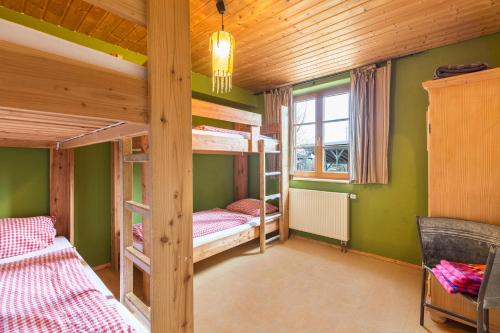 two bunk beds in a room with green walls at Ferienwohnung Tipihof in Sauldorf
