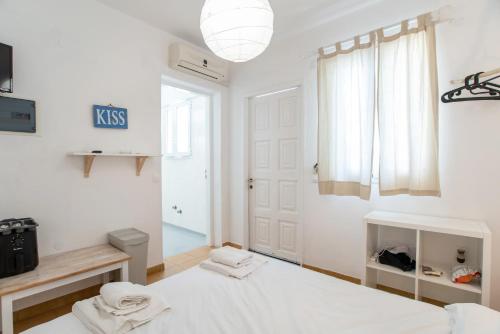 a white bedroom with a bed and a window at Livadia Seaside Studios 6 in Parikia