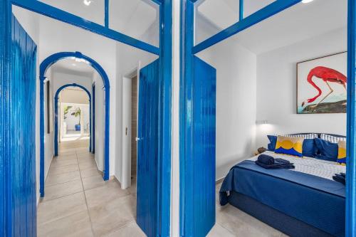 a blue bedroom with a bed and a hallway at Blue Sardine Historic Townhouse Algarve Beaches in Portimão