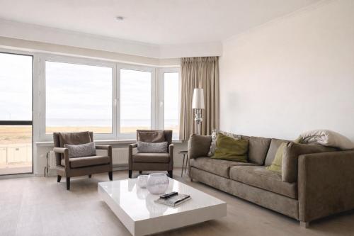 a living room with a couch and chairs and a table at Anna's Haven, Knokke in Knokke-Heist