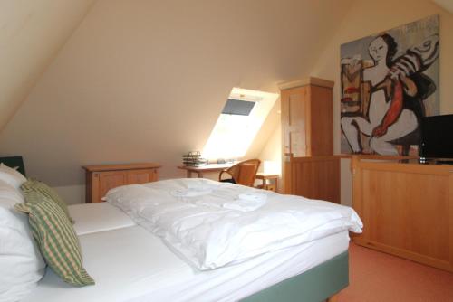 a bedroom with a white bed and a desk at Haus Kranich App 426 in Neuhaus
