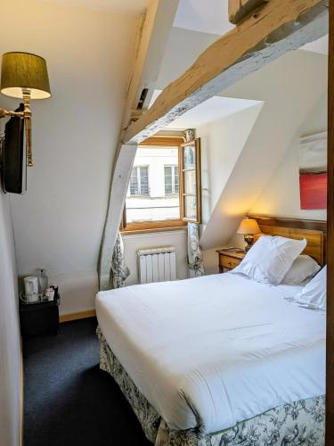 a bedroom with a large white bed in a attic at Entre Terre Et Mer in Honfleur