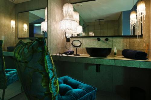a bathroom with a sink and a chair in front of a mirror at BLUE-art Ferienwohnung in Wyssachen
