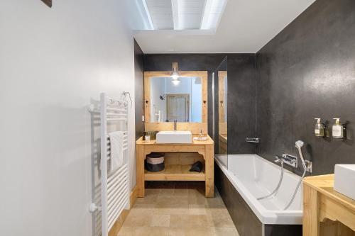 a bathroom with a tub and a sink and a bath tub at Maison d'hôtes de Gailhaguet in Verfeil