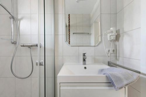 a white bathroom with a sink and a shower at Ferienwohnung Emilia in Garding
