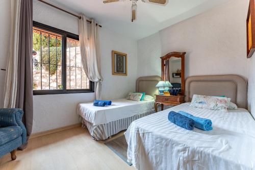 a bedroom with two beds and a mirror at Cosy house jacuzzi wifi pool view in Mijas