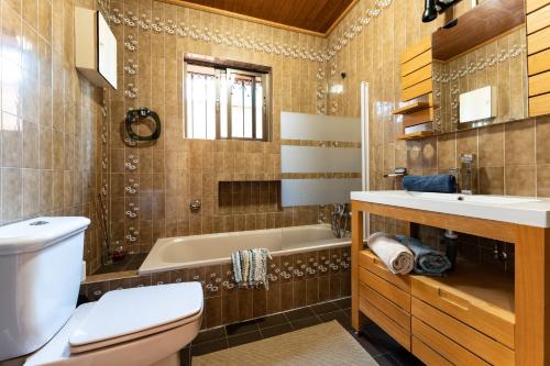 a bathroom with a tub and a toilet and a sink at Cosy house jacuzzi wifi pool view in Mijas