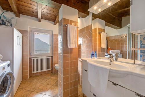 a bathroom with a sink and a washing machine at Splendido loft panoramico in Veleso