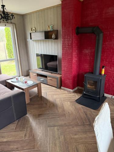 a living room with a fireplace and a tv at Bajkowe Domki Marzeń Grei in Węgorzewo