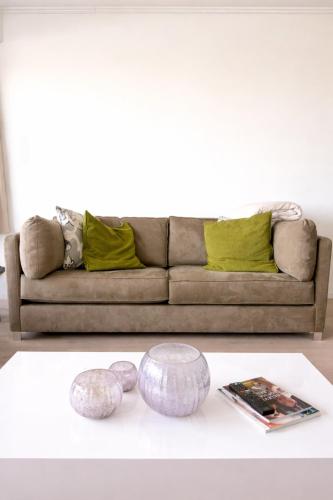 a living room with a couch and a table at Anna's Haven, Knokke in Knokke-Heist