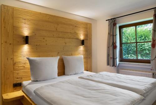a bedroom with a large bed with a wooden headboard at Ammerheimat in Oberammergau