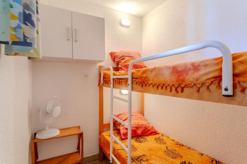a small room with two bunk beds in it at Chez Colette d'en bas in Le Barcarès