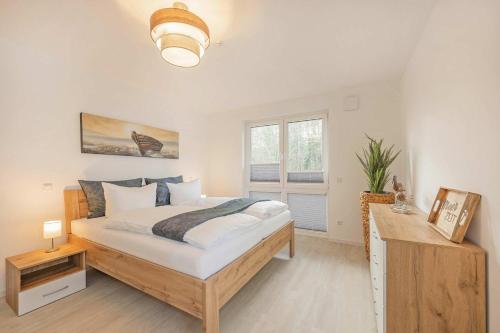 a bedroom with a large bed and a window at FeWo Meerzeit Bernsteinquartier in Loddin