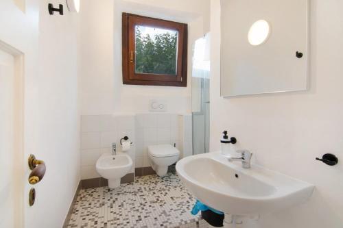 a white bathroom with a sink and a toilet at Workation Castle - Casa Tremezzo in Carlazzo
