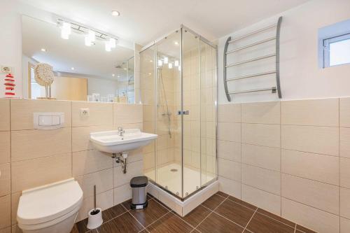 a bathroom with a shower and a toilet and a sink at Bungalow "Giny" in Bansin