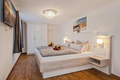 a bedroom with a large white bed with flowers on it at Bungalow "Giny" in Bansin