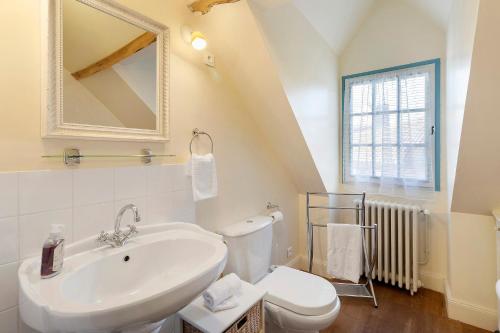 a white bathroom with a sink and a toilet at Maison historique en pierre in Issigeac