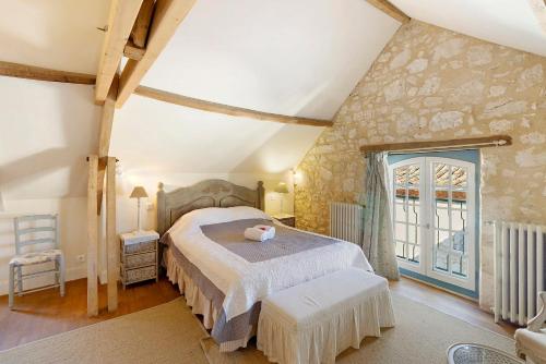 a bedroom with a large bed in a room at Maison historique en pierre in Issigeac