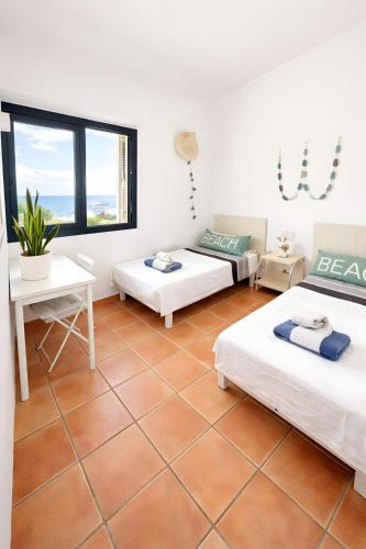 a room with three beds and a table at Duplex Laura in Es Mercadal
