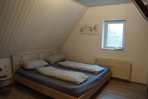 a bedroom with two pillows on a bed with a window at Quiet And Renovated Apartment in Schwendi