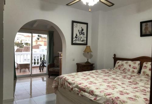 a bedroom with a bed and a door to a balcony at Townhouse with Sea View in Nerja