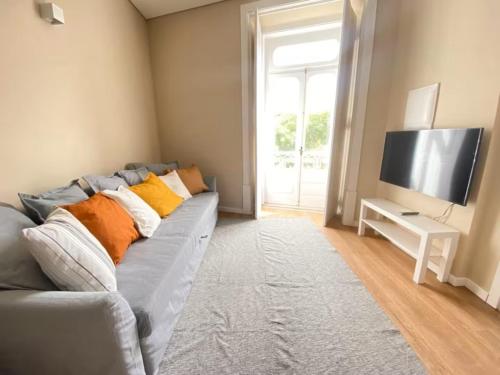 a living room with a couch and a television at Setubal Prime, By Home Match in Setúbal