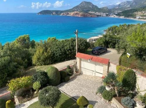 a house with a car parked in front of the ocean at Villa Maja in Sutomore