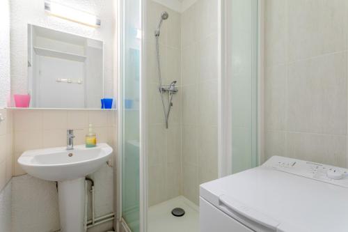 a white bathroom with a sink and a shower at Chez Colette du haut in Le Barcarès