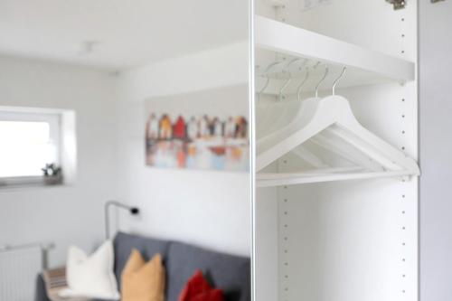 a room with a white closet with a blue couch at Ferienwohnung Emilia 2 in Garding
