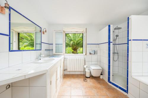 a white bathroom with two sinks and a toilet at Villa Polina in Capdepera
